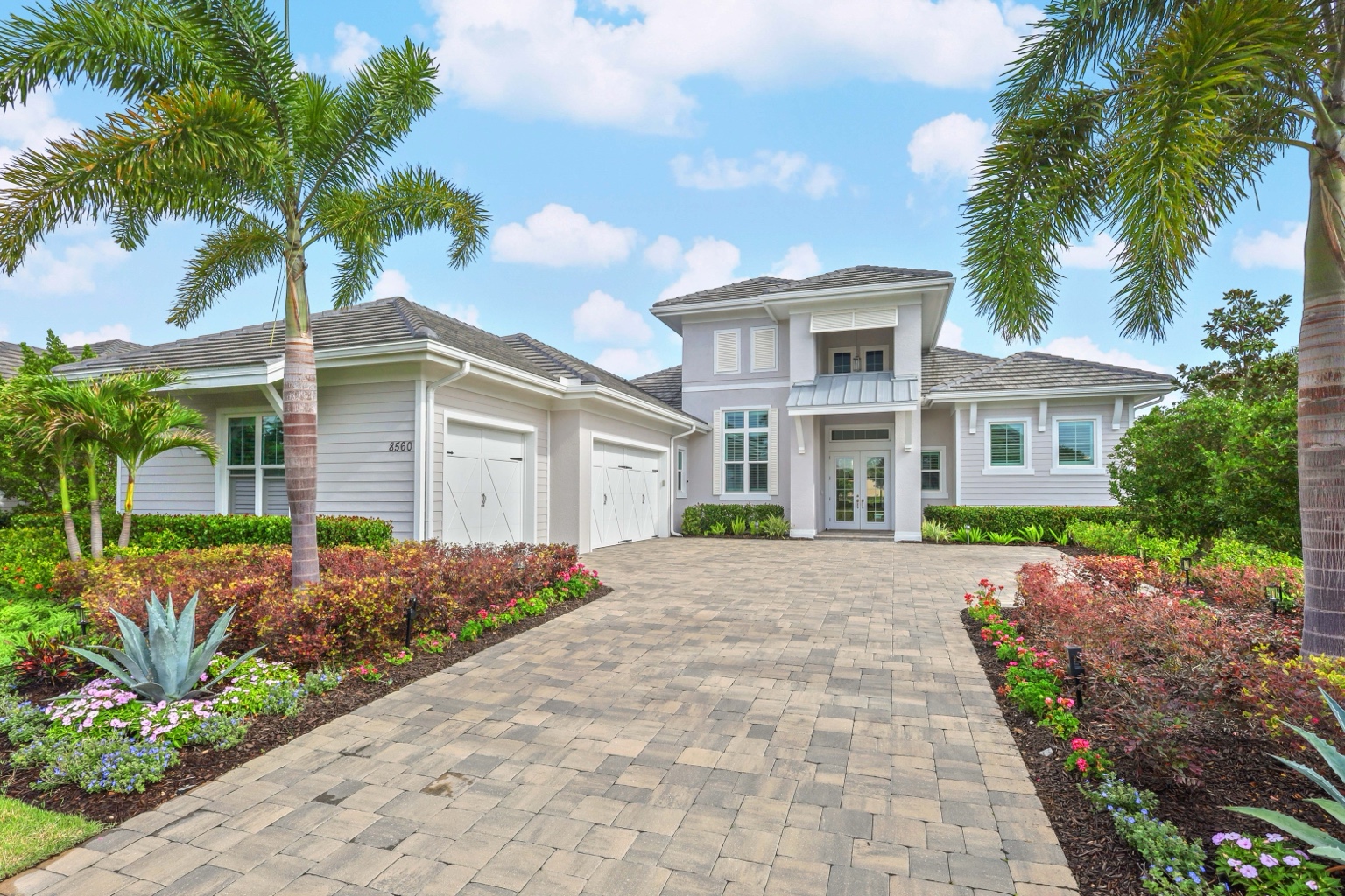 Front exterior of a Florida home framed by palms, photographed by Vuzario