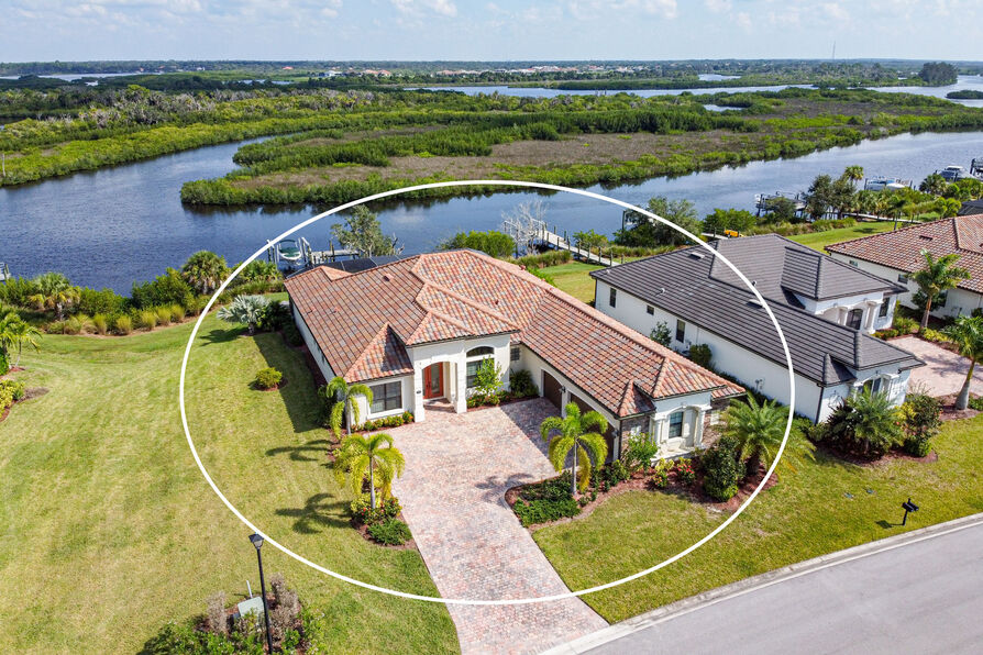 Angled aerial of a tile-roof waterfront home, selected from the Vuzario portfolio