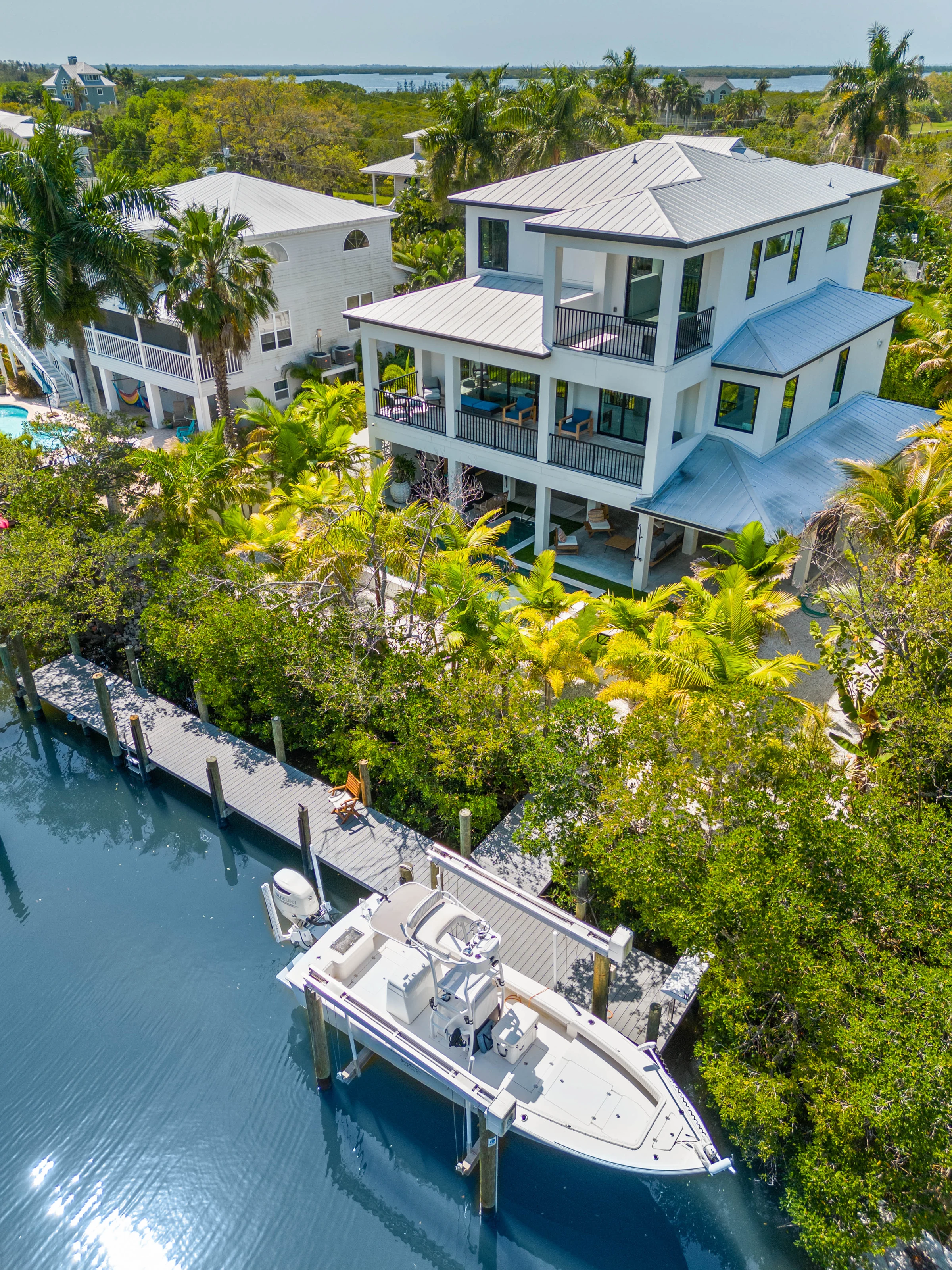 Coastal home and dock among tropical palms photographed by Vuzario