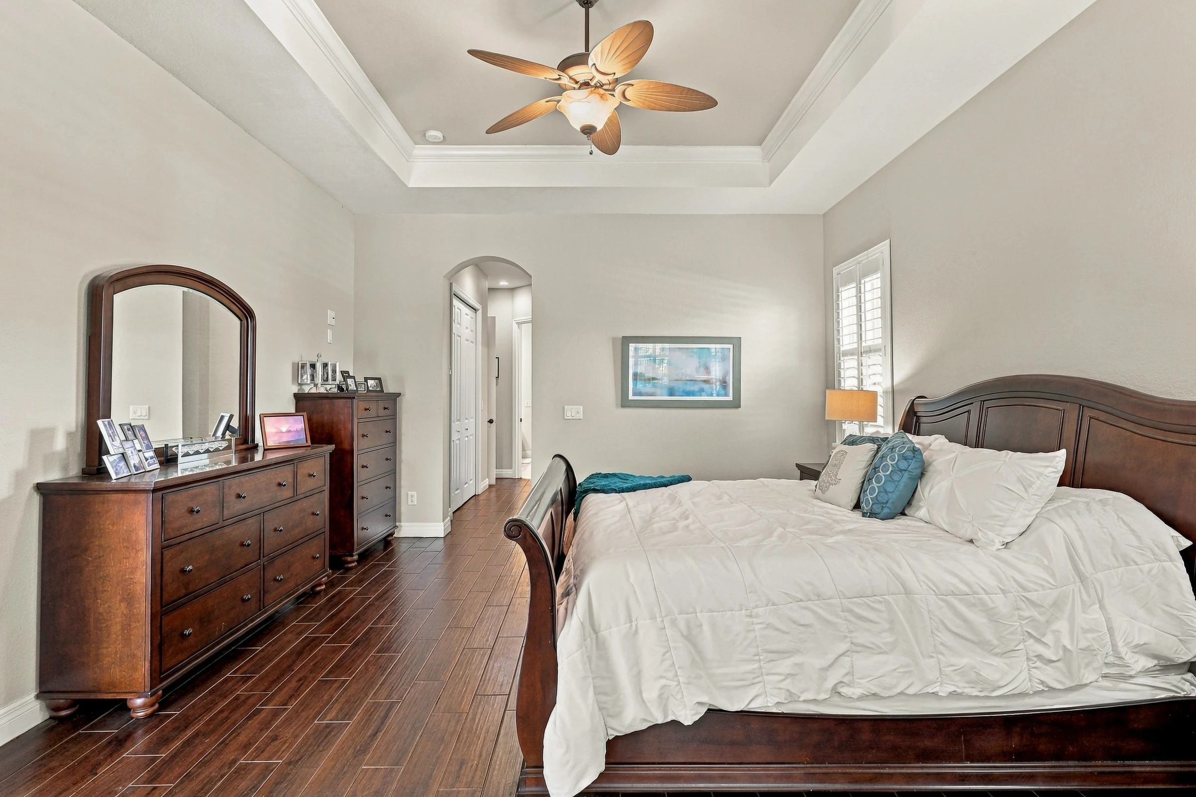 Primary bedroom with wood flooring photographed by Vuzario