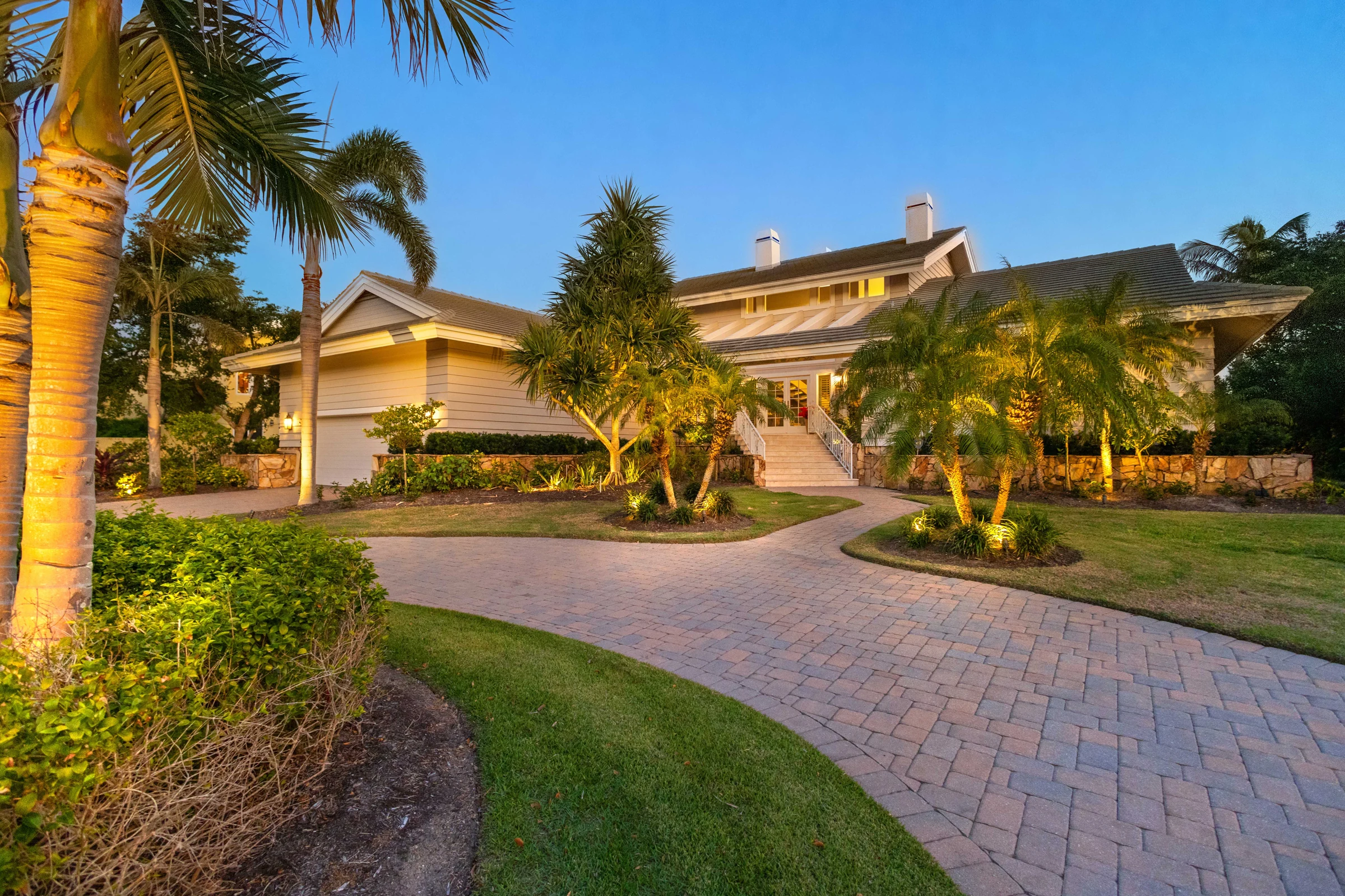 Palm-lined waterfront home at twilight photographed by Vuzario