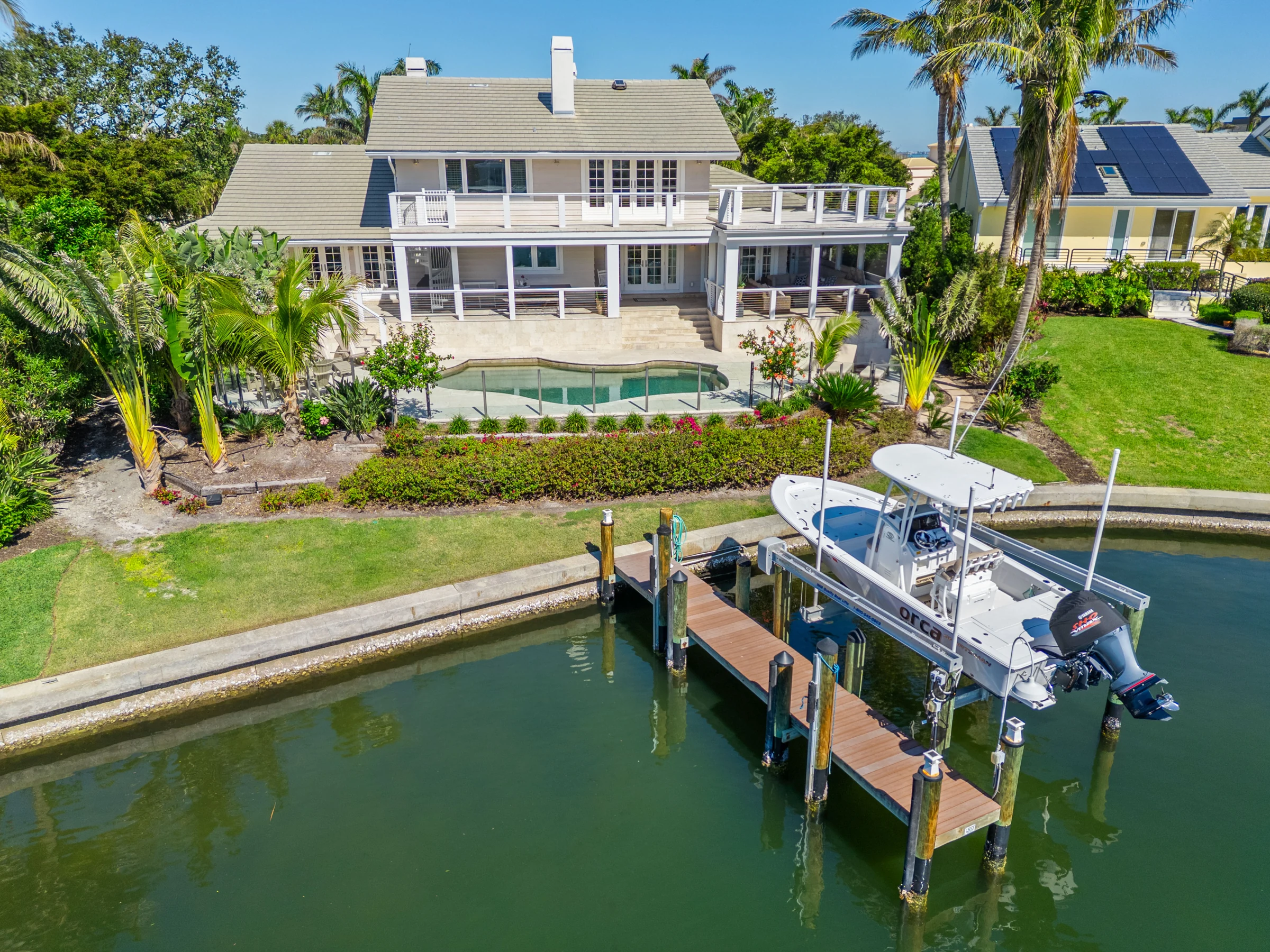 Waterfront home, dock and pool from above photographed by Vuzario