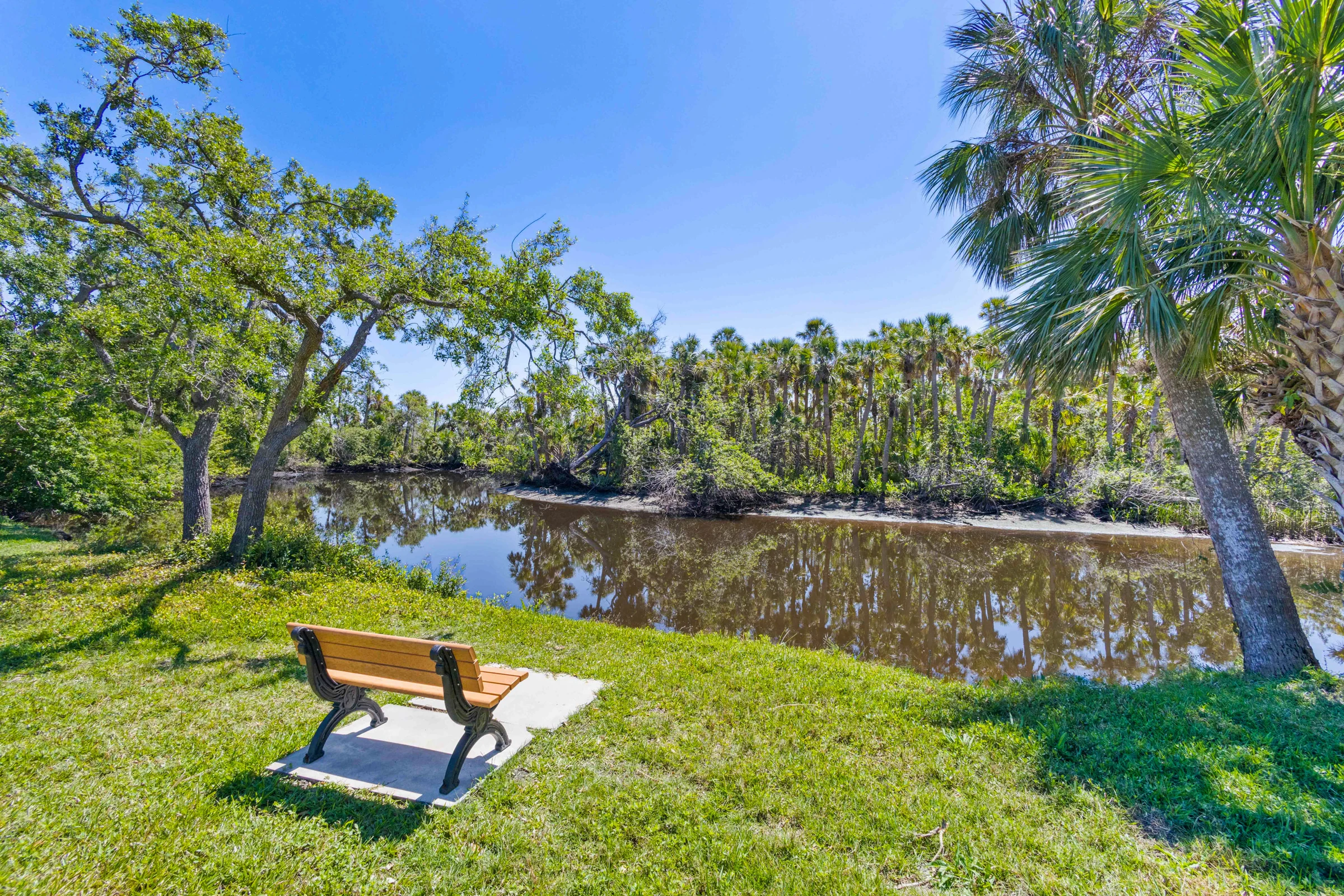 Quiet lakeside seating beneath the trees photographed by Vuzario
