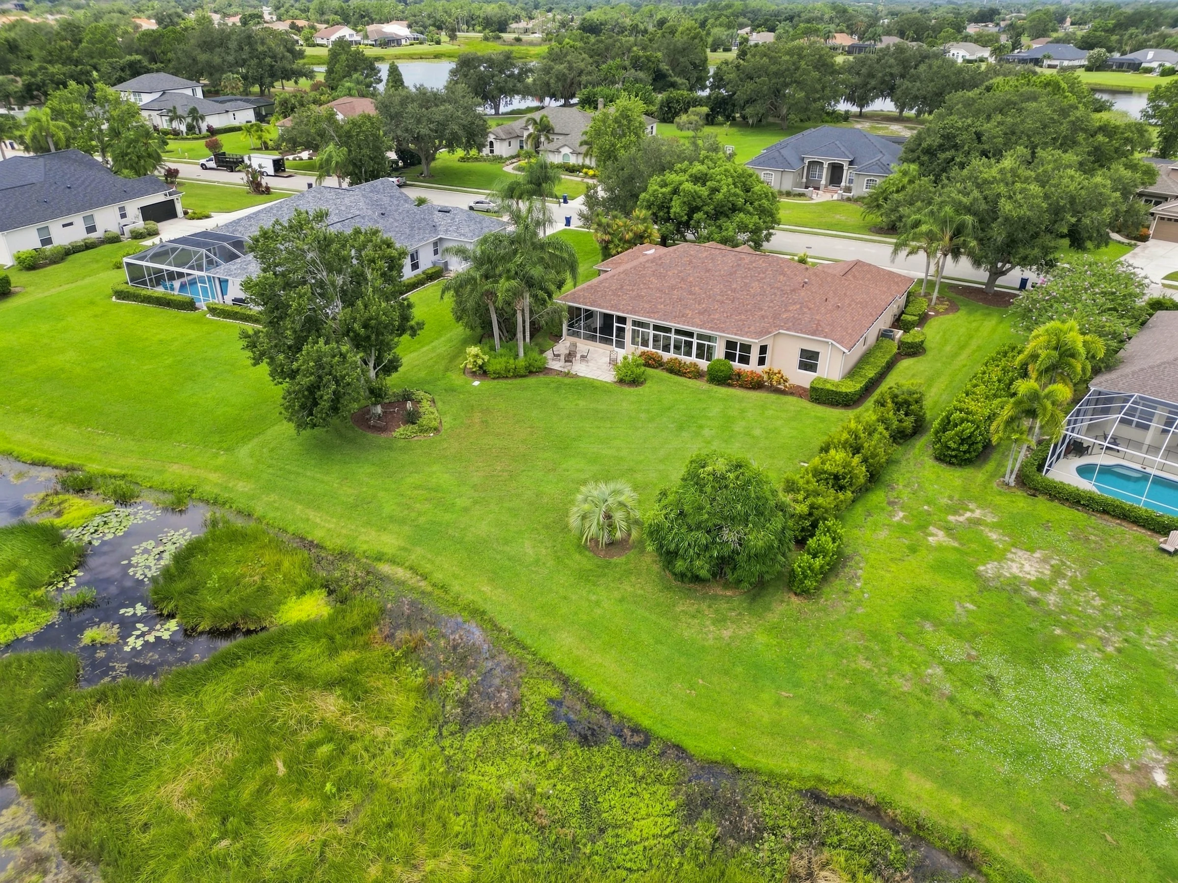 Lakeside home and green grounds from above photographed by Vuzario