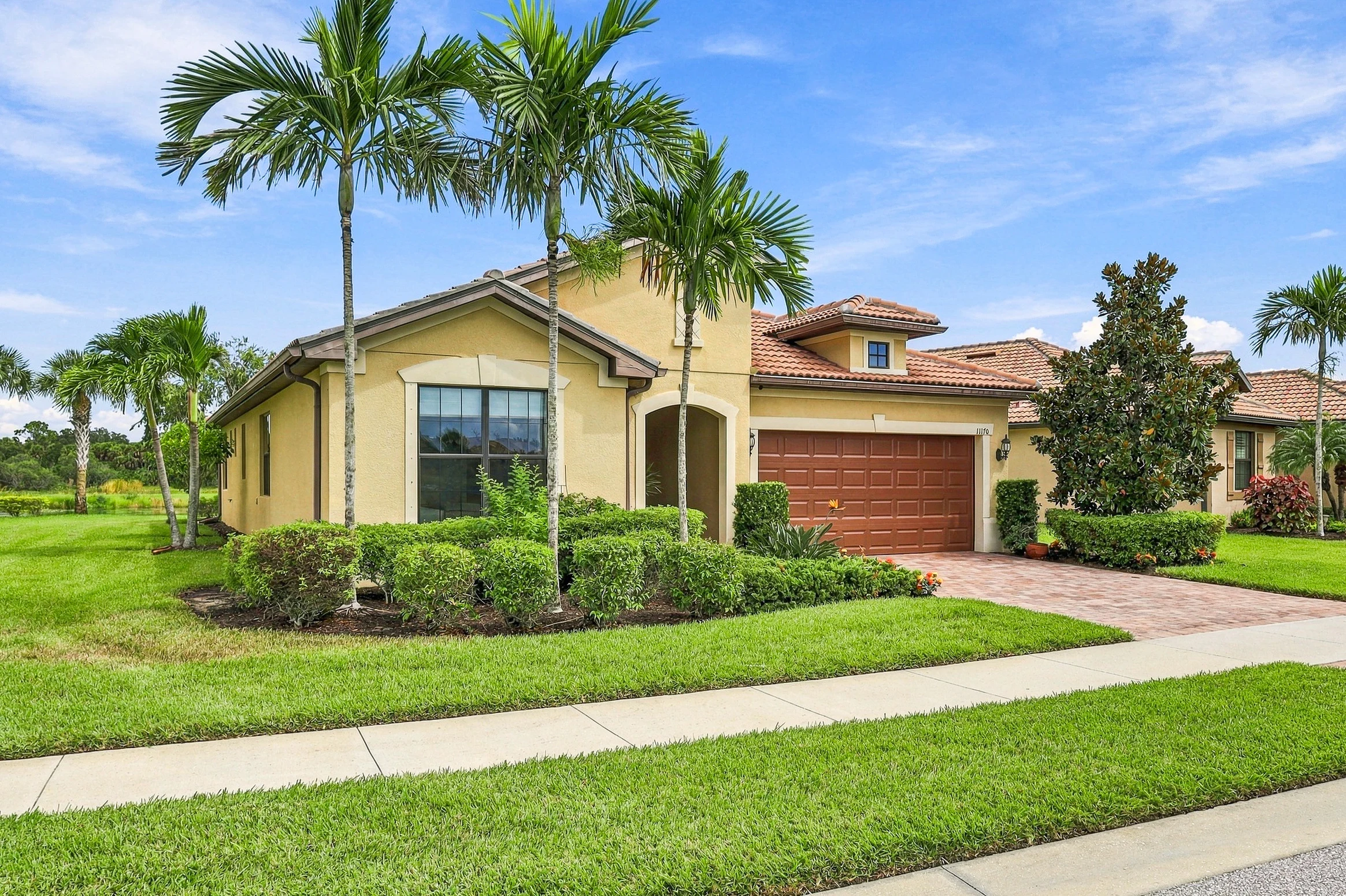 Palm-lined home and landscaped front lawn photographed by Vuzario